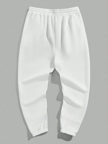 Manfinity EMRG Men'S Street Style Black Asymmetric Cross Print Tapered Sweatpants with White Track Pants.